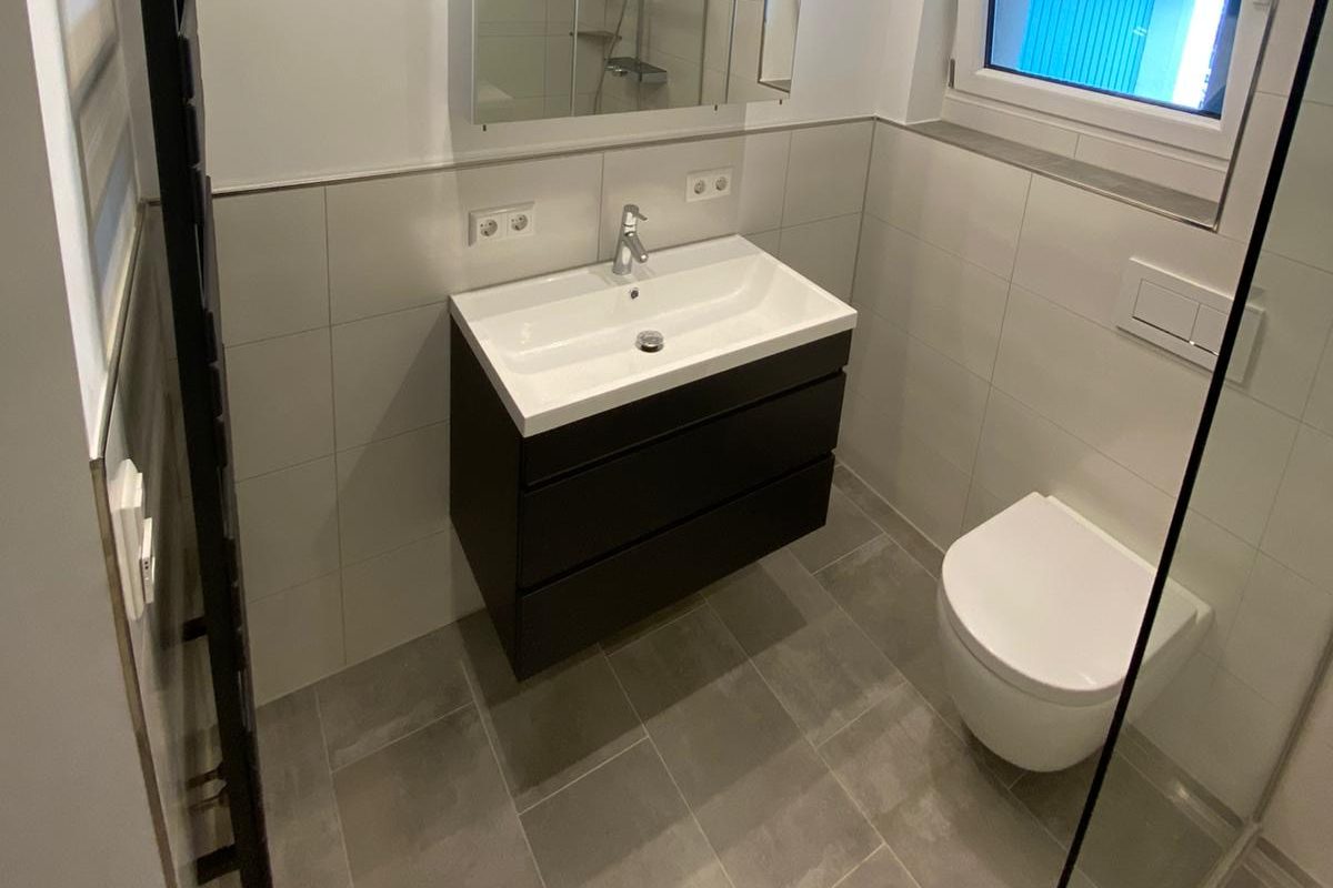Zeitgemäßes Bad mit eleganter Ausstattung Modernes Badezimmer mit freistehender Badewanne, bodengleicher Dusche und stilvollen Armaturen.